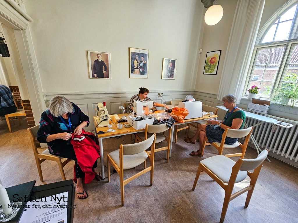 De frivillige kvinder, der sidder bag symaskinerne var ikke så vilde med at blive fotograferet, men taler gerne om alt det tøj, de har kunnet reparer, så det kan bruges igen og igen. Foto: Anders Godtfred-Rasmussen - Søften Nyt.