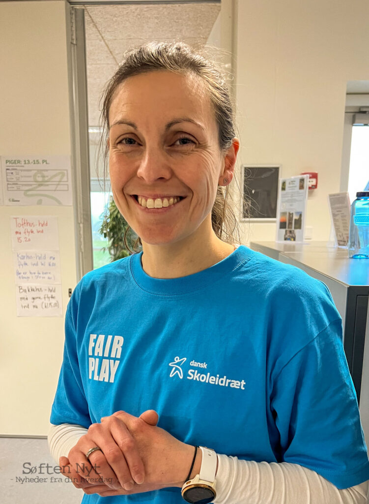 Fotografiet viser Charlotte Sørensen i en blå t-shirt, hvor der står DM i skolehåndbold og FairPlay. Charlotte er lærer på Præstemarkskolen og står for arrangementet. Foto: Anders Godtfred-Rasmussen - Søften Nyt.